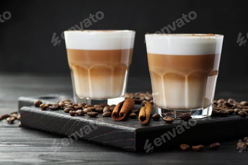 Preview: Tasty latte macchiato in glasses, coffee beans and cinnamon on black wooden table, closeup