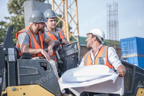 Preview: Site manager talking with steamroller drivers about blueprint on construction site