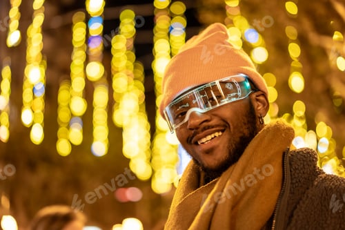 Preview: Cool african man wearing smart glasses outdoors at night