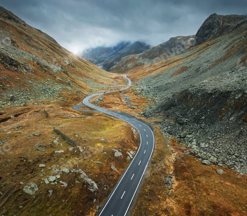 Preview: Aerial view of winding mountain road in alpine valley in autumn