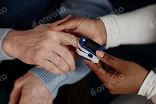 Preview: Black Female Nurse Using Oximeter Testing Elderly Mans Blood Oxygen Saturation Indoors