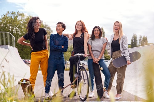 Preview: Portrait Of Female Friends With Skateboards And Bike In Urban Skate Park