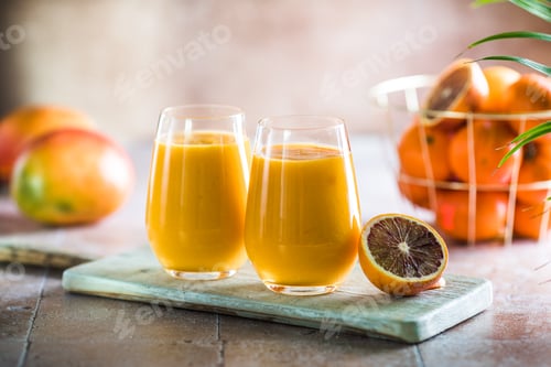 Preview: Two mango lassi or kesar milk in glasses. Indian healthy ayurvedic cold drink with mango.
