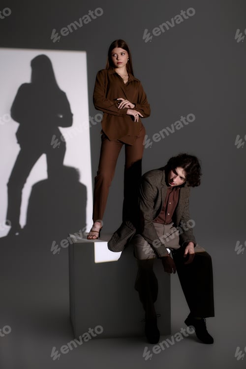Preview: Stylish young couple showcasing modern fashion in a dark grey studio