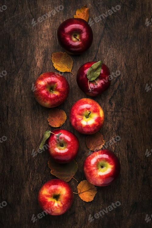Preview: Autumn food background. Ripe apples with fallen leaves on rustic wooden table