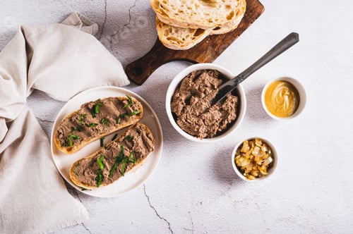 Preview: Sandwiches with chicken liver pate and herbs on a plate on the table top view