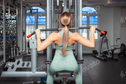 Preview: young woman doing exercises in gym