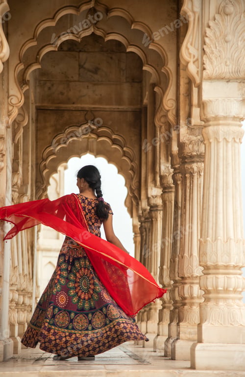 Preview: Young female tourist dancing between arches and Pillars.