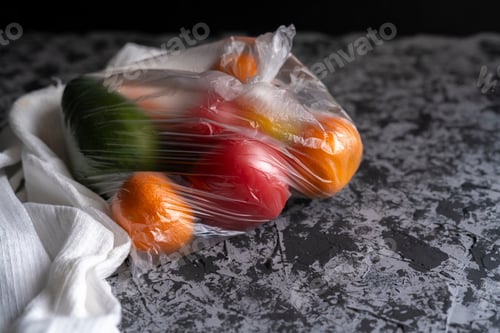 Preview: damaged spoiled fruits in a bag in a dark room, plastic container harm concept b