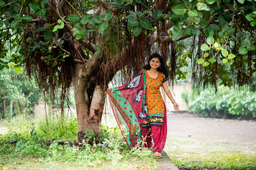 Preview: Happy Indian woman near banyan tree
