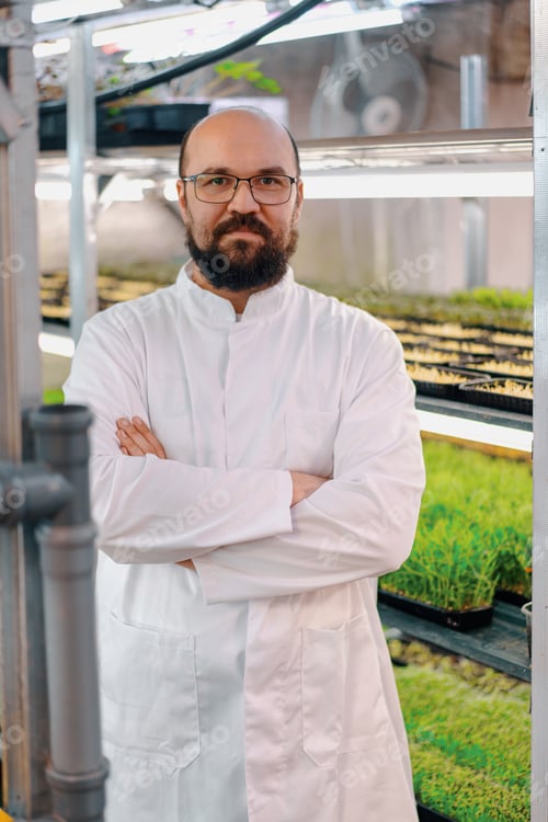 Preview: gardener in glasses and white coat at microgreen farm Healthy vegan food Organic plant germination