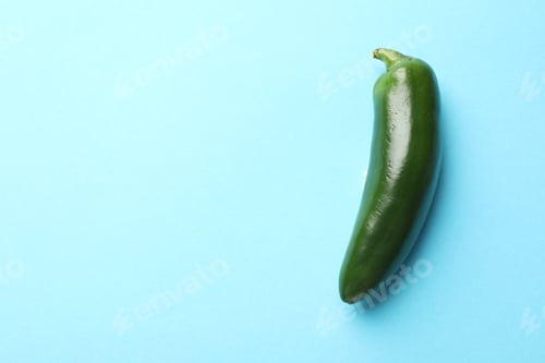 Preview: Green jalapeno pepper on light blue background, top view. Space for text