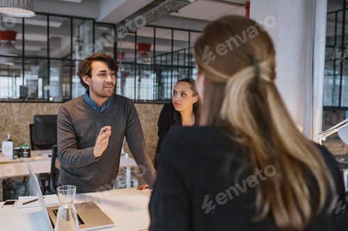 Preview: Young man explaining new business plan to coworkers