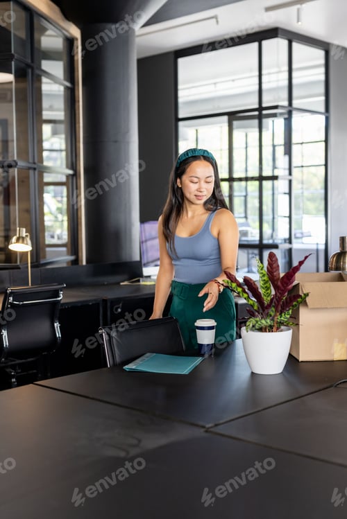 Preview: Businesswoman organizing office desk with notebook and coffee, preparing for meeting