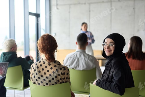 Preview: A diverse group of business professionals sits attentively in a modern office, actively