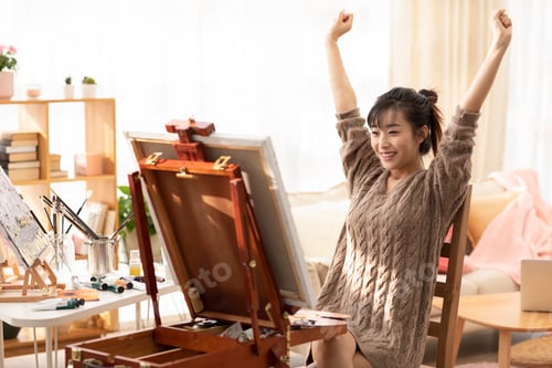 Preview: Young Chinese woman painting at home