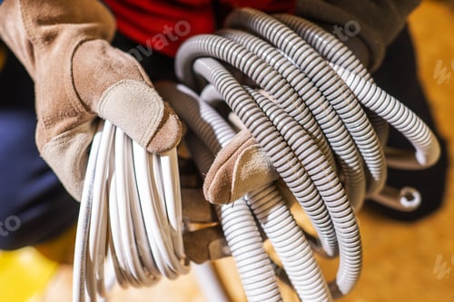 Preview: Electrician with Plastic Electric System Conduits in His Hands