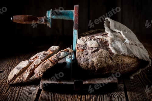 Preview: Closeup of homemade loaf of bread on slicer