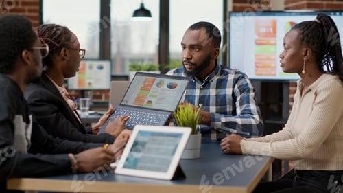 Preview: Team of african american employees analyzing financial charts on laptop