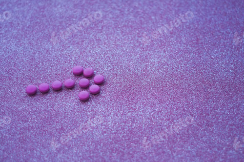 Preview: An arrow from pink medicines on the glittery background.