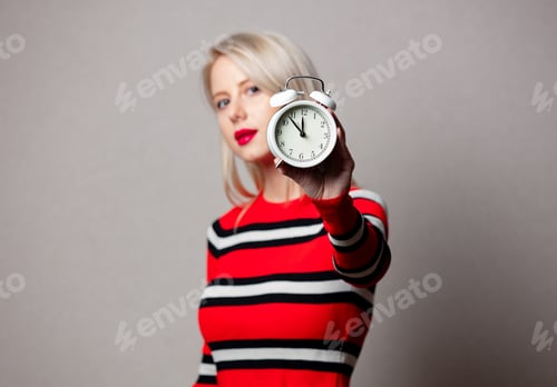 Preview: Style girl in red sweater with alarm clock