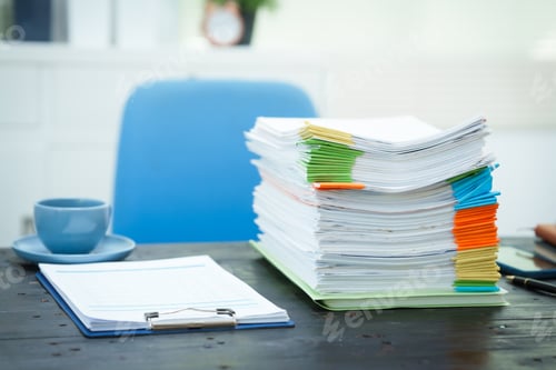 Preview: An empty office desk is cluttered with numerous documents scattered coffee cups.The scene reflects