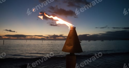 Preview: Tiki torch burning flame during evening at beach