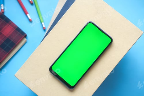 Preview: top view of smart phone and notepad on table