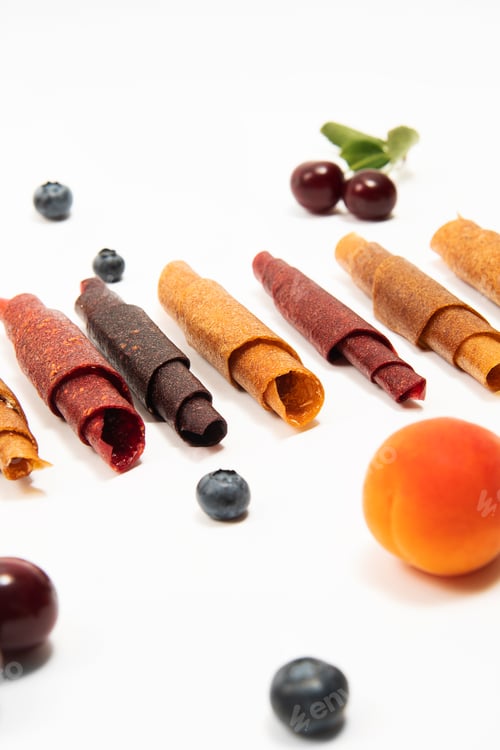Preview: Pattern pastila fruit leather rolls up with fruits on white background. Vertical.