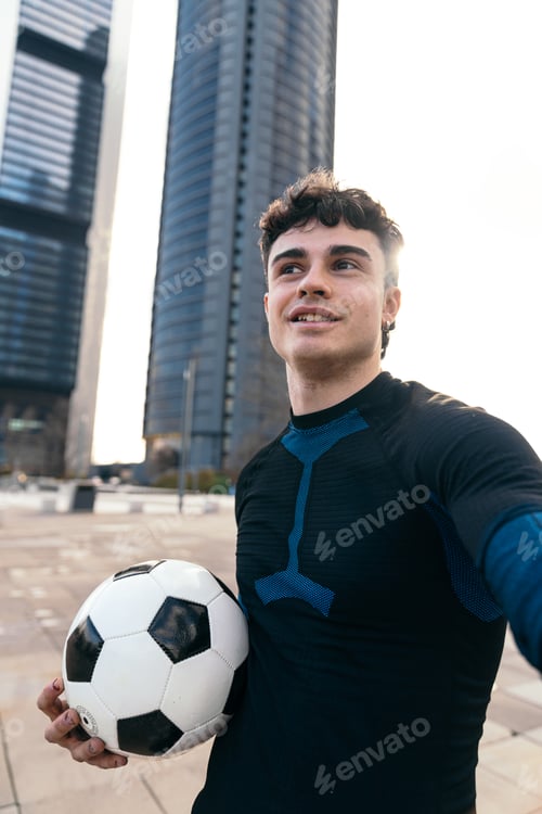 Preview: Young man performing freestyle soccer skills in city