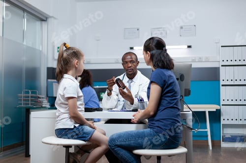Preview: African american pediatrician doctor holding pills bottle explaining medicine prescription