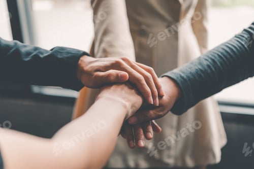 Preview: Hands of business people come together in a stack of hands to symbolize collaboration