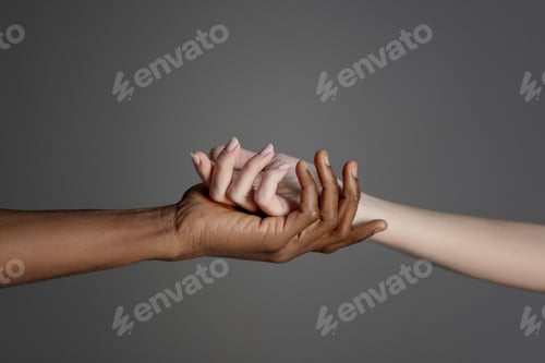 Visualização: Mãos de casal inter-racial em fundo cinza