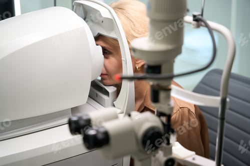 Preview: Elegant woman sits in front of a special ophthalmic device