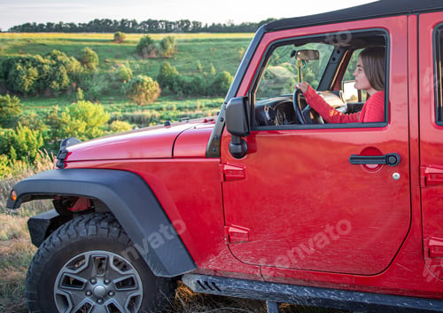 Preview: A young woman driving an SUV in the countryside.