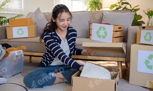 Preview: A young woman separates unused clothes and prepares them for donation or recycling in order to