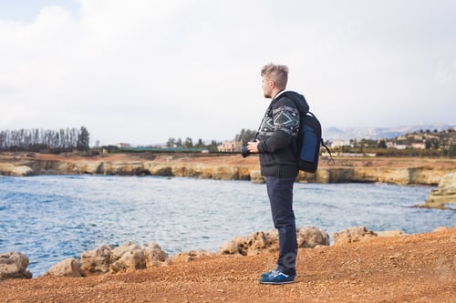 Preview: Young photographer on the beach. Traveler photographer with digital camera