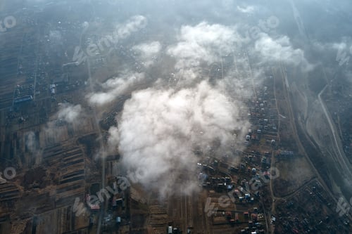 Preview: Aerial view from high altitude of distant city covered with puffy cumulus clouds forming before