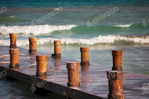 Preview: A wooden pier with posts or bollards on the coastline