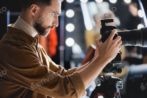 Preview: side view of photographer taking photo with digital camera on backstage