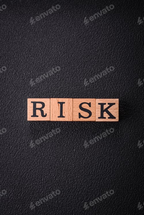 Preview: The inscription risk with wooden cubes on a dark concrete background