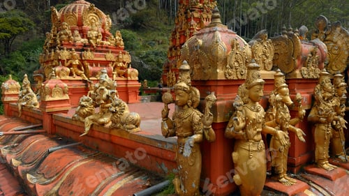 Preview: Malaysian temple with golden statues of the saints. Action. Concept of religion and culture.