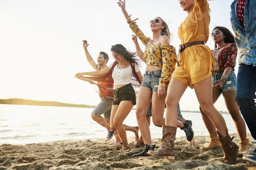 Preview: Happy friends running on beach at sunset