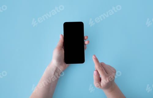 Preview: Female hands holding and using smartphone with mockup for your design on blank screen over blue