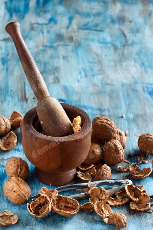 Preview: Fresh walnuts and mortar on a blue wooden table
