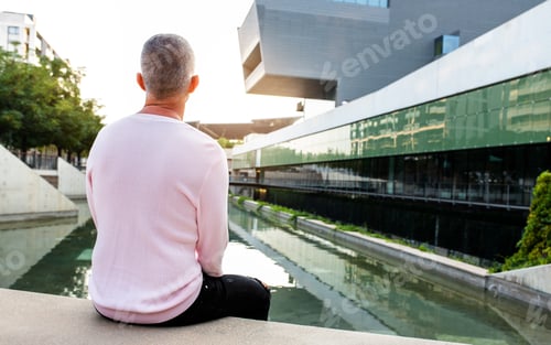 Preview: Caucasian man looking to a serene modern city view. Relaxing in the city. Copy space.