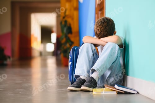 Preview: Little boy sitting alone on floor after suffering an act of bullying.