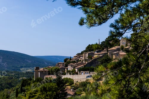 Preview: beautiful green trees, traditional houses and scenic mountains in provence, france