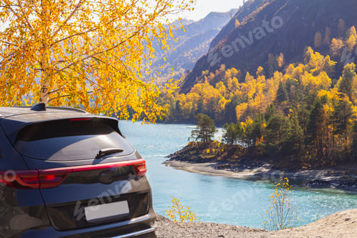Preview: Rear view of black car, parked in rest area or lookout road, mountain blue river backdrop.