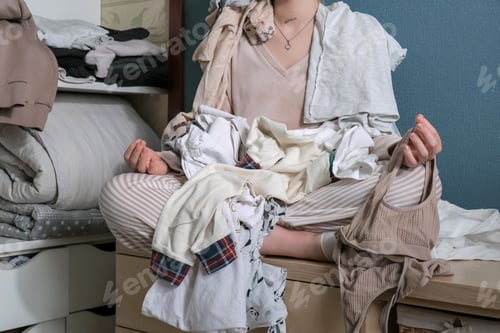 Preview: Fast fashion, the girl puts things in order in the closet. A bunch of colorful clothes. The concept